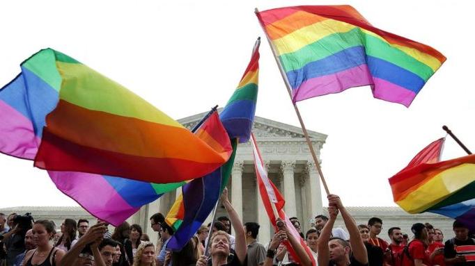 gay flags raised against a backdrop of people and the supreme court